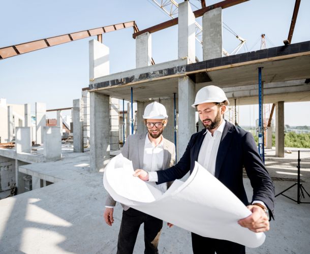 Zwei Geschäftsleute diskutieren und planen Strategien an einer Glaswand im Büro.